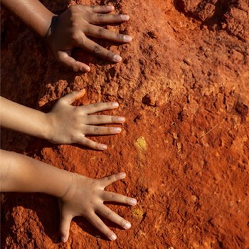 Kids hands placed on some dirt