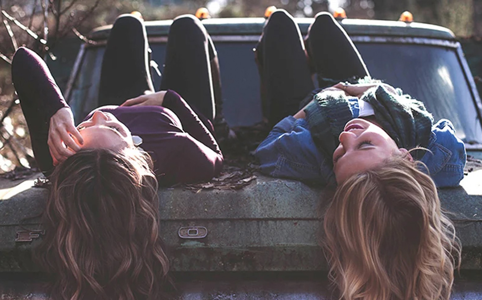 Two young people laying backwards on a couch